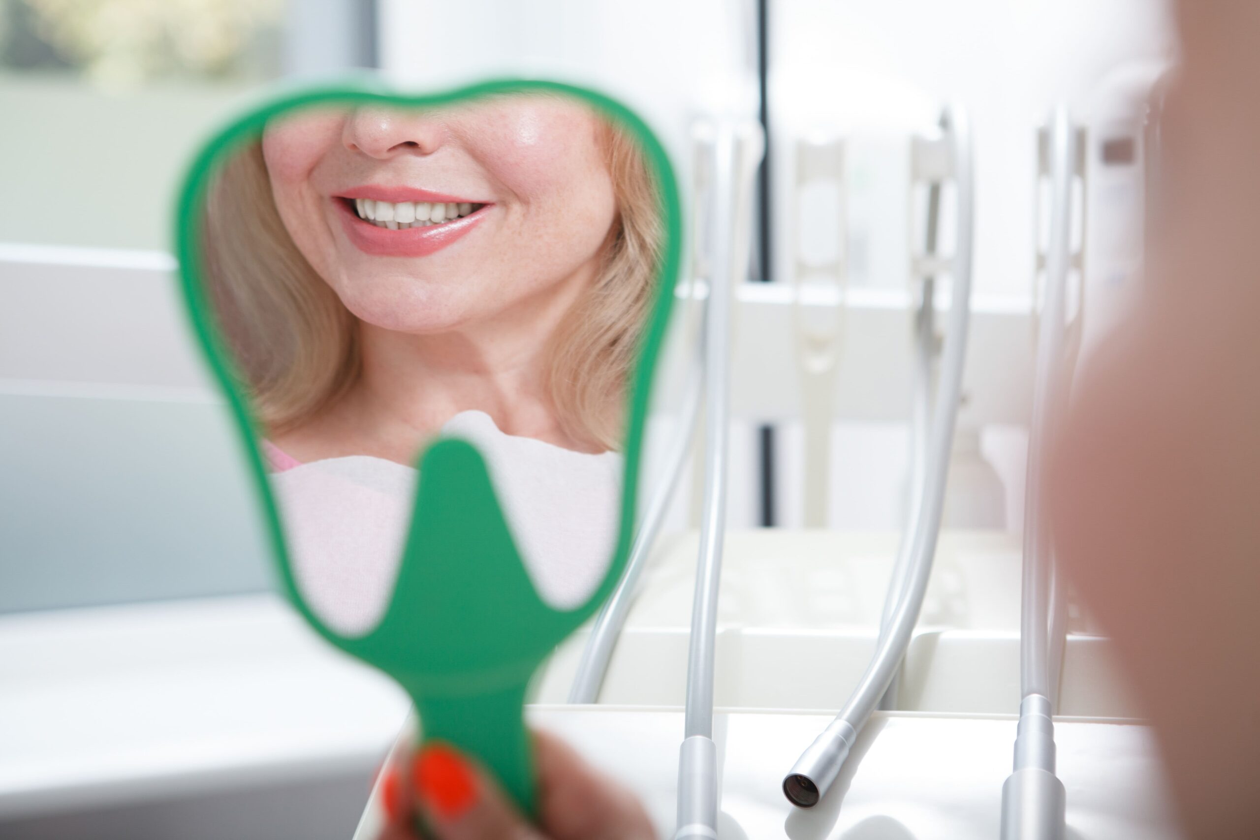 Paciente revisando su sonrisa frente al espejo tras consulta con dentista en A Coruña